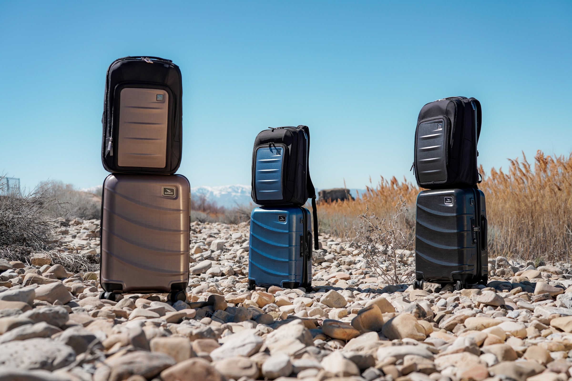desert and snow mountains with Blue copper brown Carbon Duravo Venture backpacks and carry-on